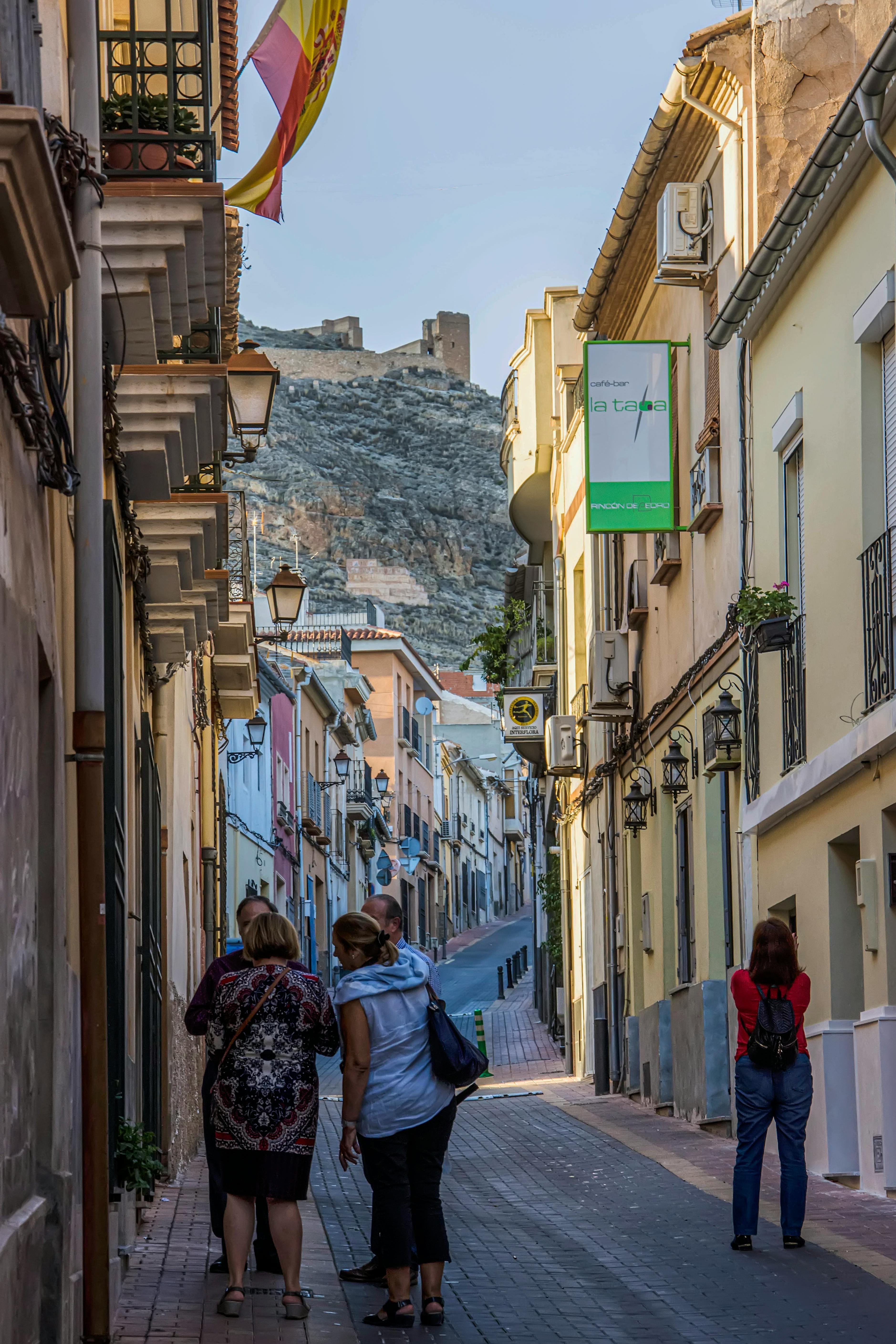 A narrow street in Lorca with the castle ruins visible on the hillside beyond, showing the inland historic character of this day trip from Murcia.